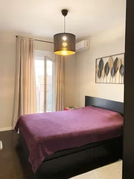 Furnished bedroom with a double bed, window, and air conditioning unit. - image 4
