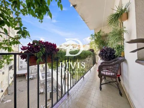 Natkriveni balkon sa metalnom ogradom, ukrašen saksijama sa cvećem i pruža pogled na grad. - image 17
