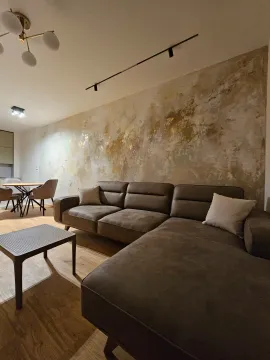 Modern living room with a sectional sofa and a decorative wall. - image 4