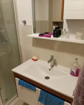 Bathroom with a washbasin, mirror and shower cabin. - image 5