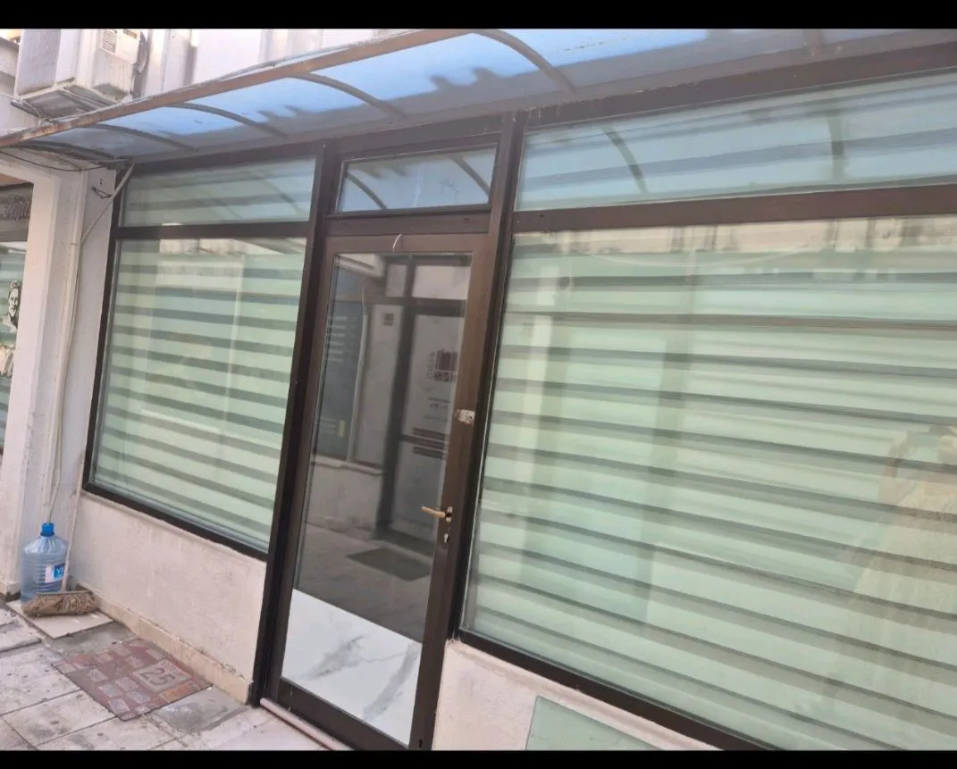 Entrance to a commercial space with a glass storefront and canopy.