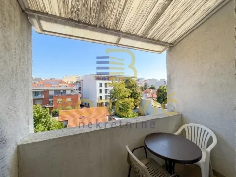 Natkriveni balkon sa garniturom za sedenje i pogledom na grad. - image 8