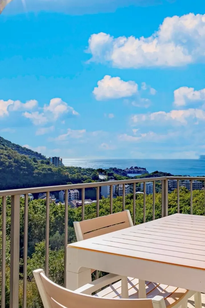 Terrace with a dining table and a view of the sea and nature.