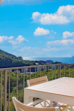 Terrace with a dining table and a view of the sea and nature. - image 8