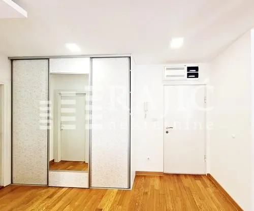 Bright room with a built-in wardrobe and wooden flooring.