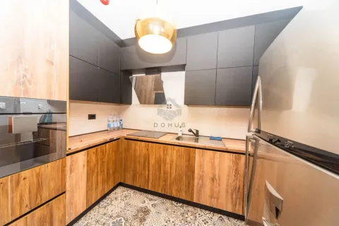 Moderna kuhinja sa drvenim elementima, tamnim gornjim ormarićima i ugrađenim uređajima. - image 5