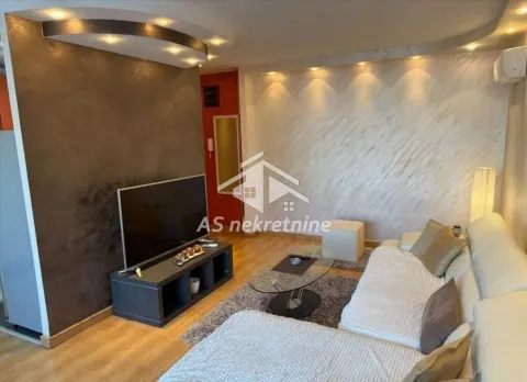 Dnevna soba sa ugaonom garniturom, televizorom i modernim osvetljenjem. - image 2