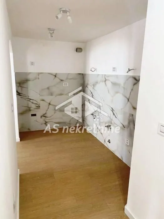 Prazna kuhinja sa keramičkim pločicama na zidu.
