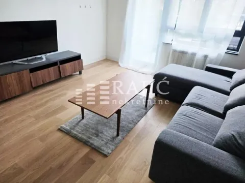 Living room with a sofa, TV, and coffee table. - image 5