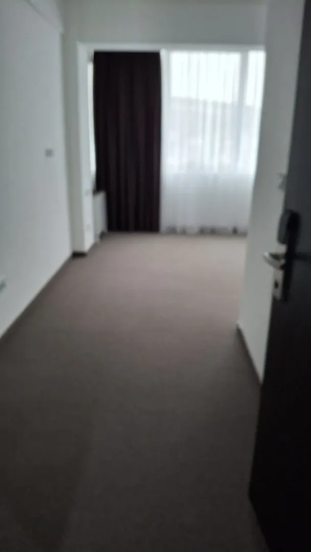 An empty room with carpet and a window.