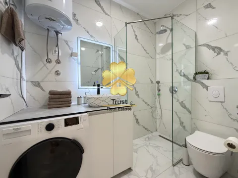 Modernly equipped bathroom with a walk-in shower and a washing machine. - image 10