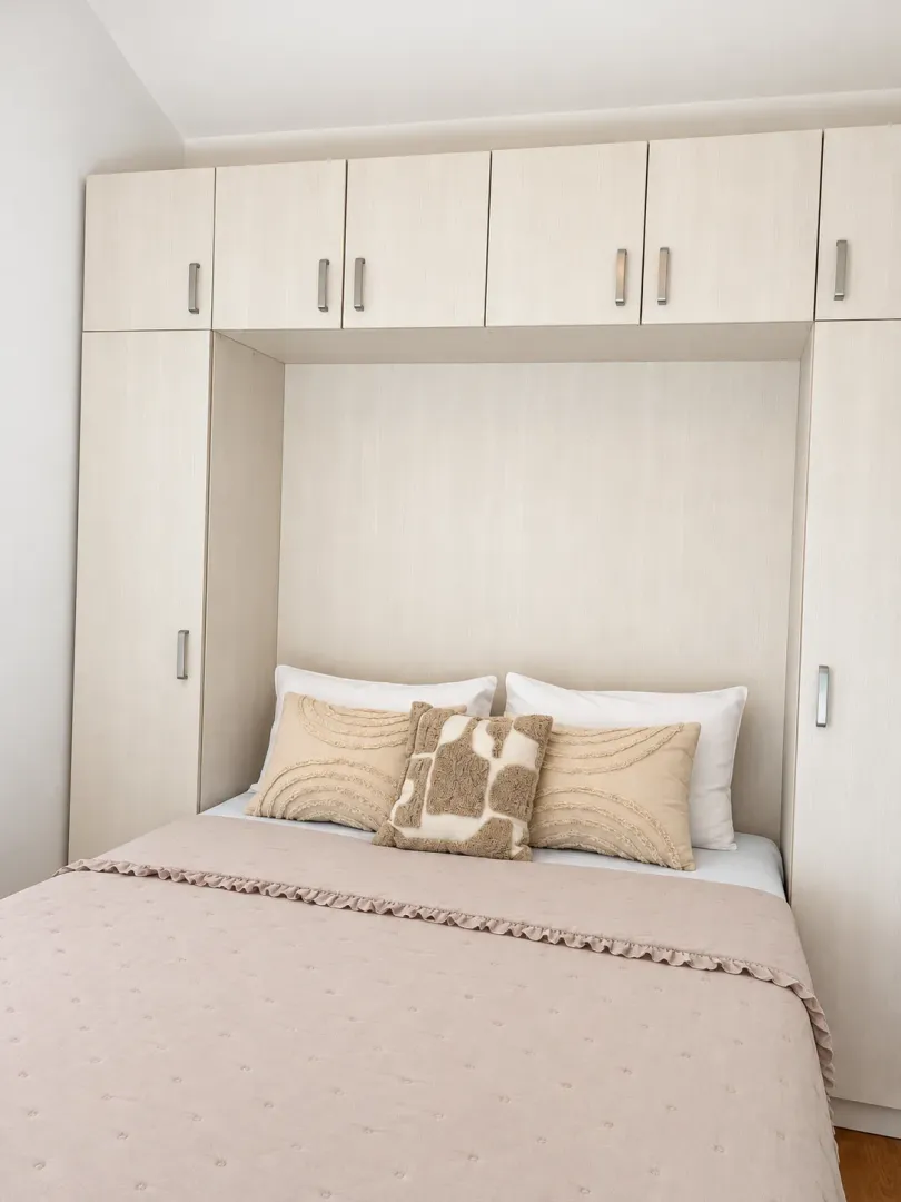 Furnished bedroom with built-in closets around the bed.