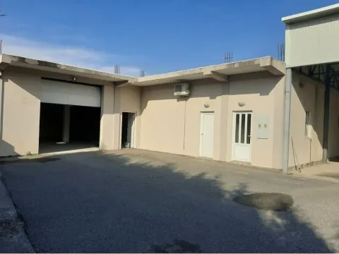 Exterior of a commercial building with a spacious driveway and garage doors. - image 2