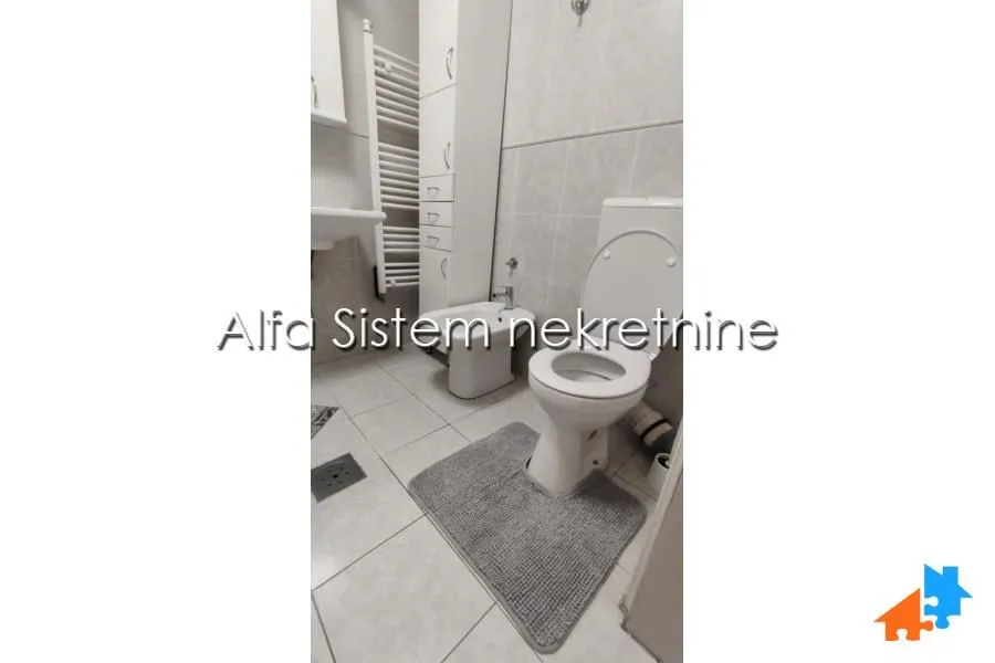 Smaller bathroom with sanitary ware, tiles, and a built-in cabinet.