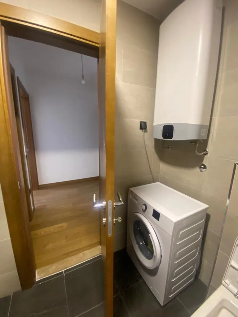 Bathroom with a washing machine and a water heater.