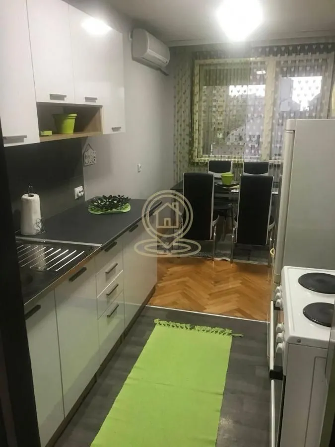 Kuhinja sa trpezarijom i belim elementima.