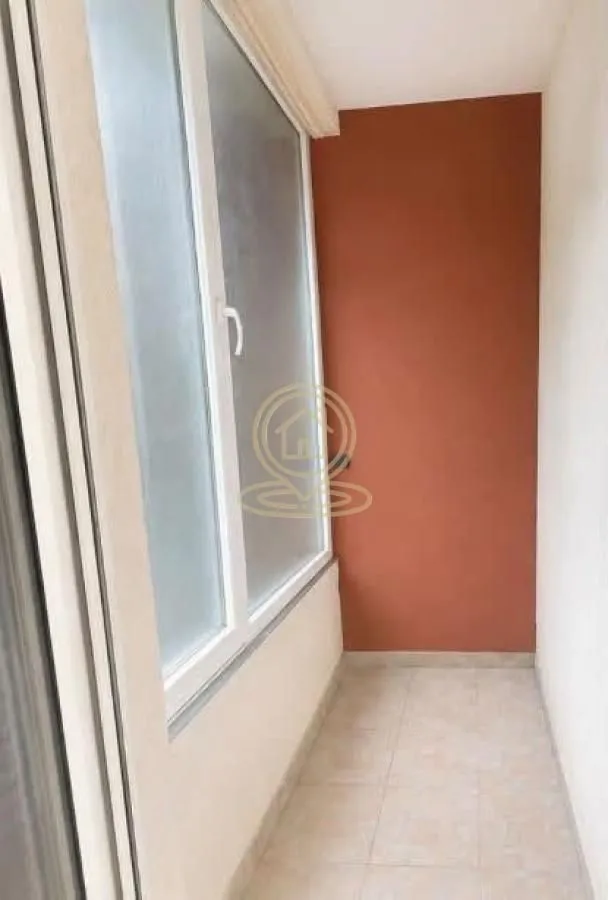 Manji zatvoreni balkon sa velikim prozorom i popločanim podom.