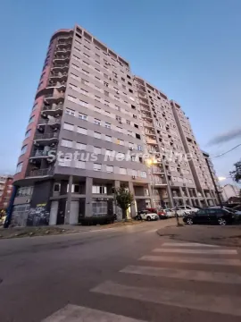 Pogled na spoljašnjost stambene zgrade sa parkingom ispred. - image 2