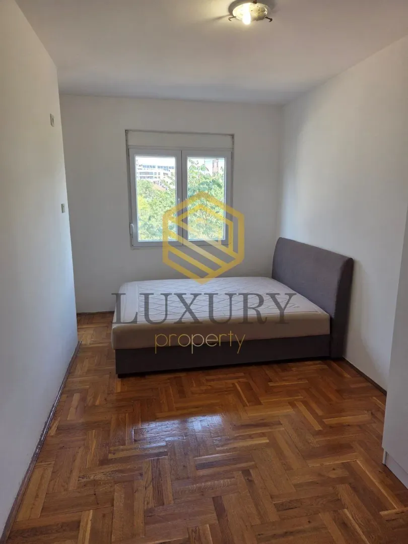 Small bedroom with a double bed and parquet flooring.