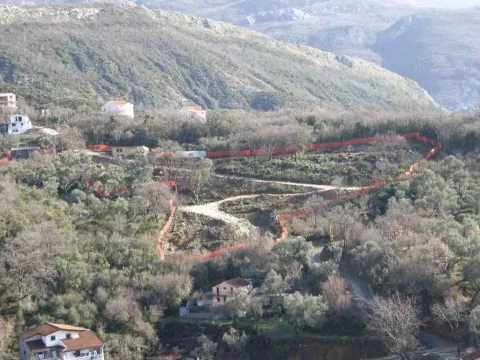 Pogled na ograđeni plac na brdu okružen prirodom i zelenilom. - image 3