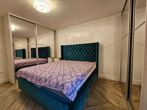 A bedroom with a large double bed and built-in mirrored wardrobes. - image 7