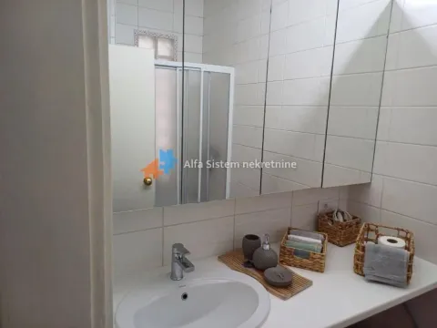 Pogled na umivaonik sa ogledalom i kupatilskim nameštajem. - image 12