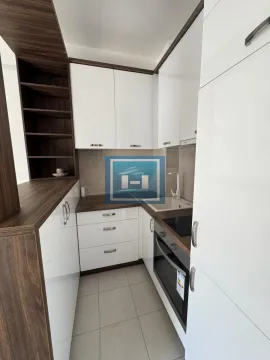 Manja kuhinja sa belim sjajnim elementima i drvenim radnim površinama. - image 6