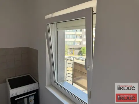 Pogled kroz otvoreni prozor iz kuhinje na okolne zgrade i ulicu. - image 9
