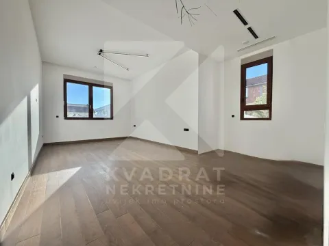 Empty room with white walls, wooden flooring and two windows. - image 2