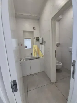 Modern bathroom equipped with a washbasin and marble-textured tiles. - image 7