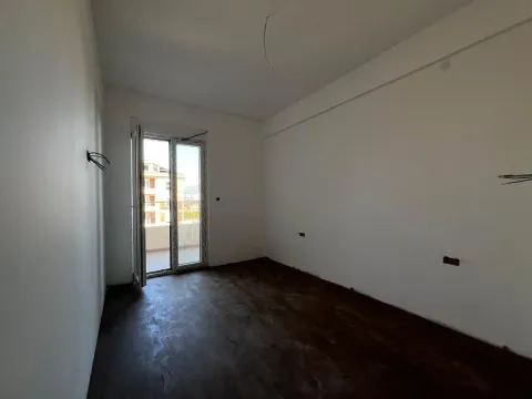 Nenamještena prostorija sa tamnim podom i izlazom na terasu. - image 5