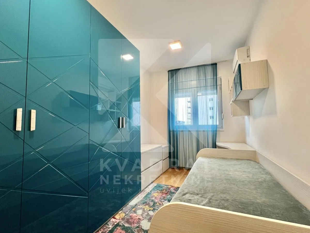 Small bedroom with a bed and a blue wardrobe.