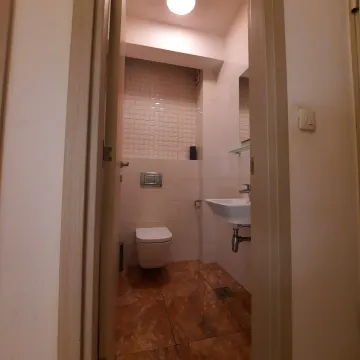 Malo kupatilo sa toaletom i lavaboom viđeno kroz otvorena vrata. - image 3