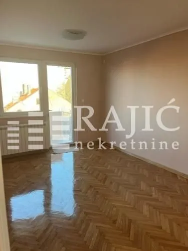 Empty room with hardwood flooring and access to the balcony.