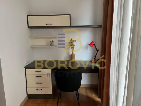 A desk with a chair and wall units in the room. - image 6