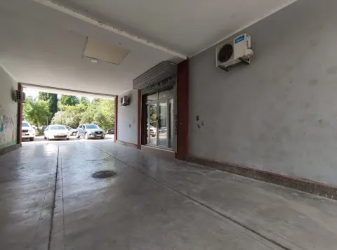 Covered driveway and entrance to a commercial space with glass doors. - image 6