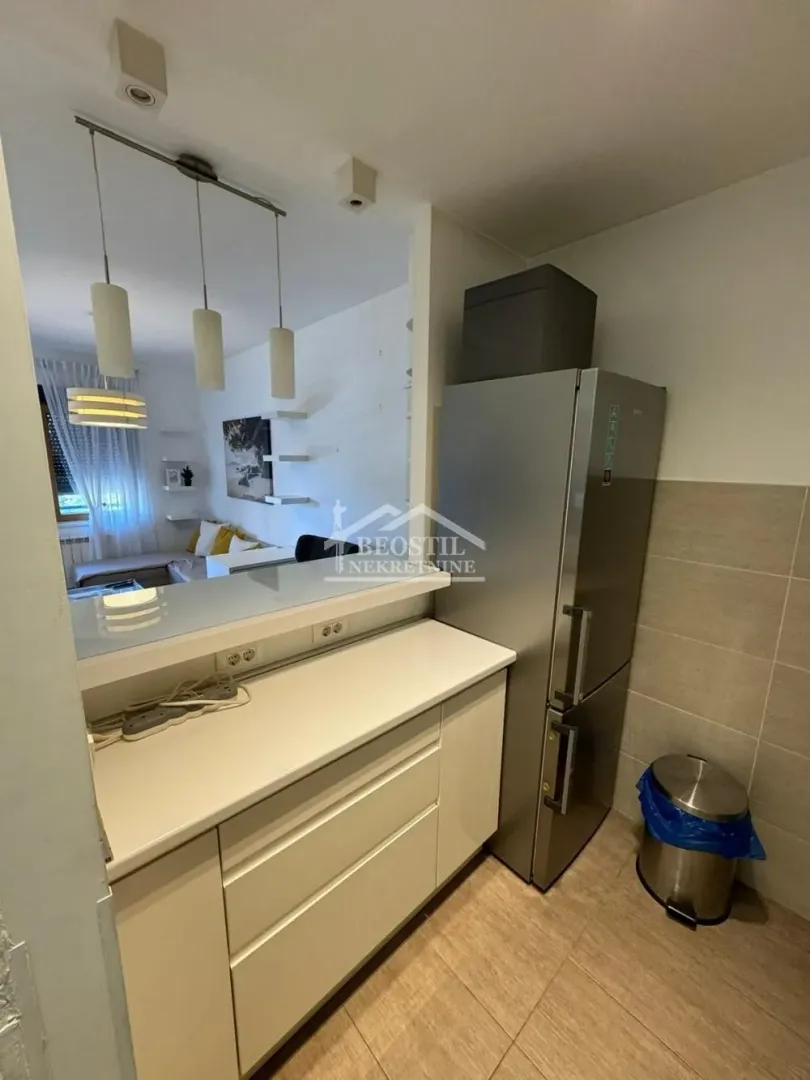 Kitchen with a countertop and refrigerator, overlooking the living room.