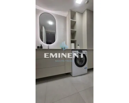 Modernly equipped bathroom with a washbasin, mirror, and washing machine. - image 9