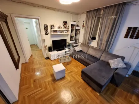 Dnevna soba sa ugaonom garniturom, televizorom i drvenim podom. - image 2