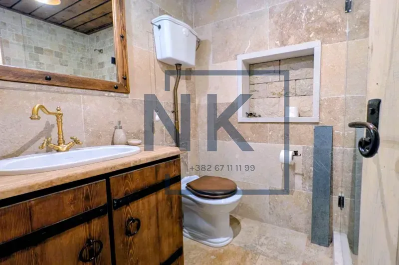 Rustically decorated bathroom with a wooden vanity sink and toilet.