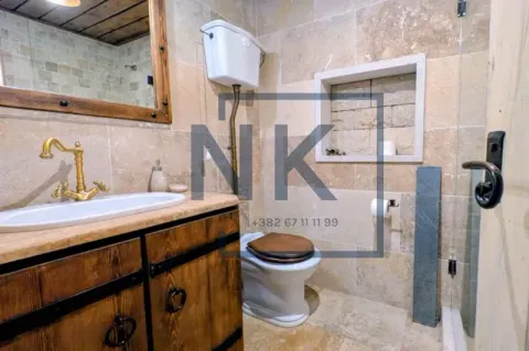 Rustically decorated bathroom with a wooden vanity sink and toilet. - image 13