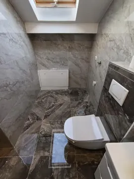 Kupatilo obloženo keramičkim pločicama sa ugradnim ormarićem i krovnim prozorskim otvorom. - image 9