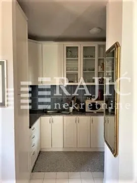 Small kitchen with white cabinets and dark tiles. - image 3
