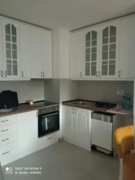 White kitchen with a built-in oven, hob, and sink. - image 4