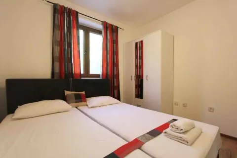 Svijetla spavaća soba sa dva kreveta i bijelim ormarom. - image 19