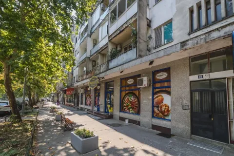 Pogled na spoljašnjost zgrade sa trotoarom i lokalom u prizemlju. - image 13