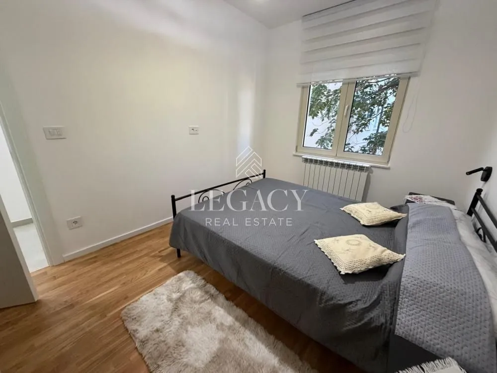 Bedroom with a double bed, wooden floor, and a window.