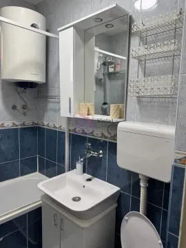 Manje kupatilo sa plavim i bijelim pločicama, umivaonikom, WC šoljom i bojlerom. - image 6