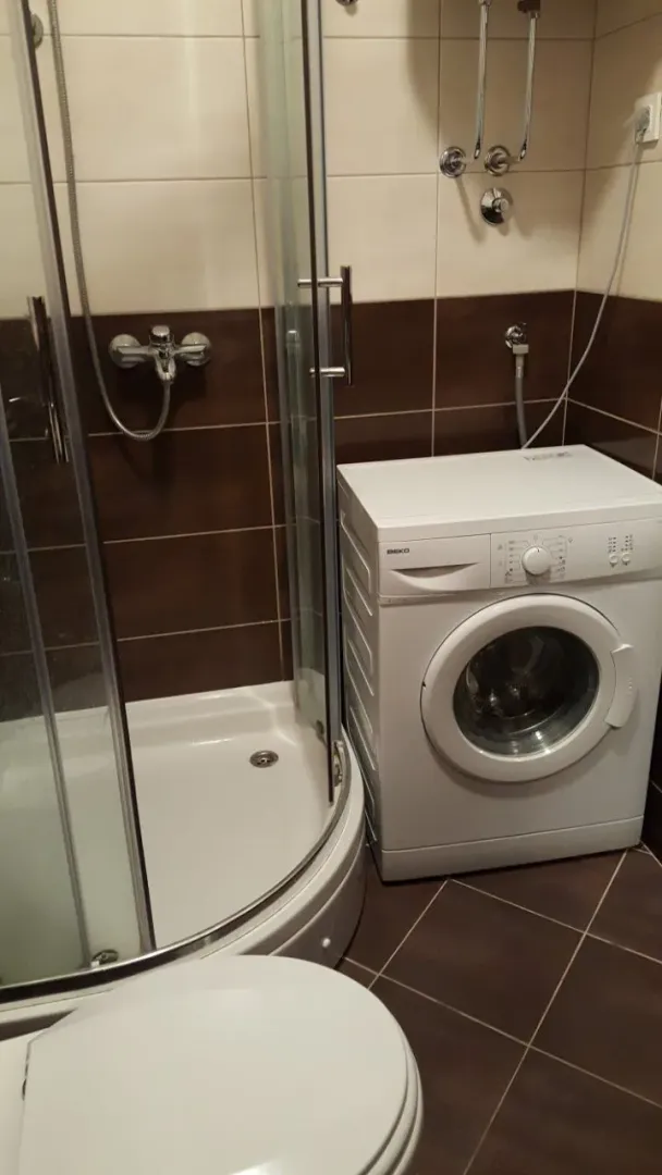 Bathroom with a shower cabin and a washing machine.