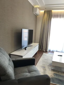 Bright living room featuring a television on a stand and a comfortable armchair. - image 19